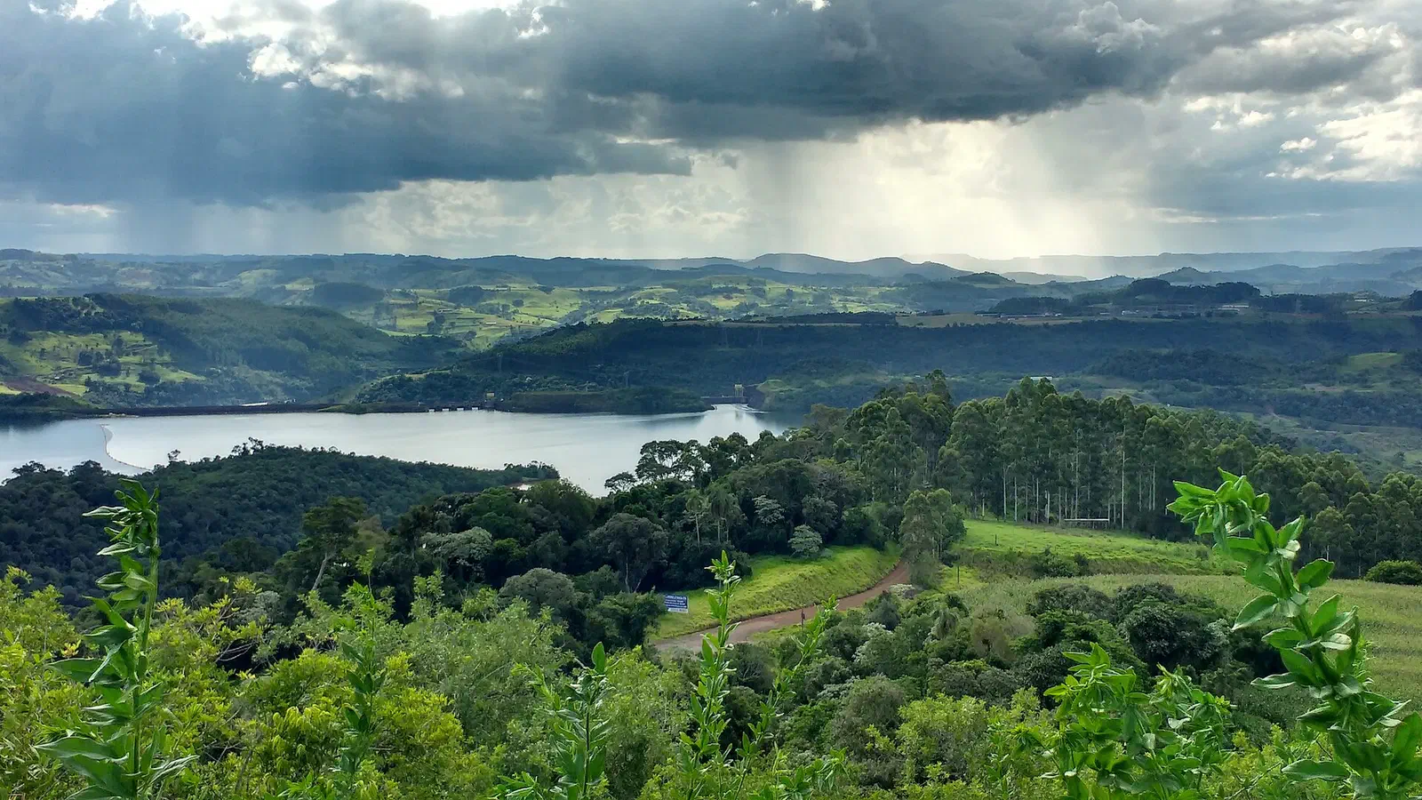 Vista panorâmica do rio Uruguai entre morros verdes e nuvens de chuva, no oeste de Santa Catarina (região de Itá)