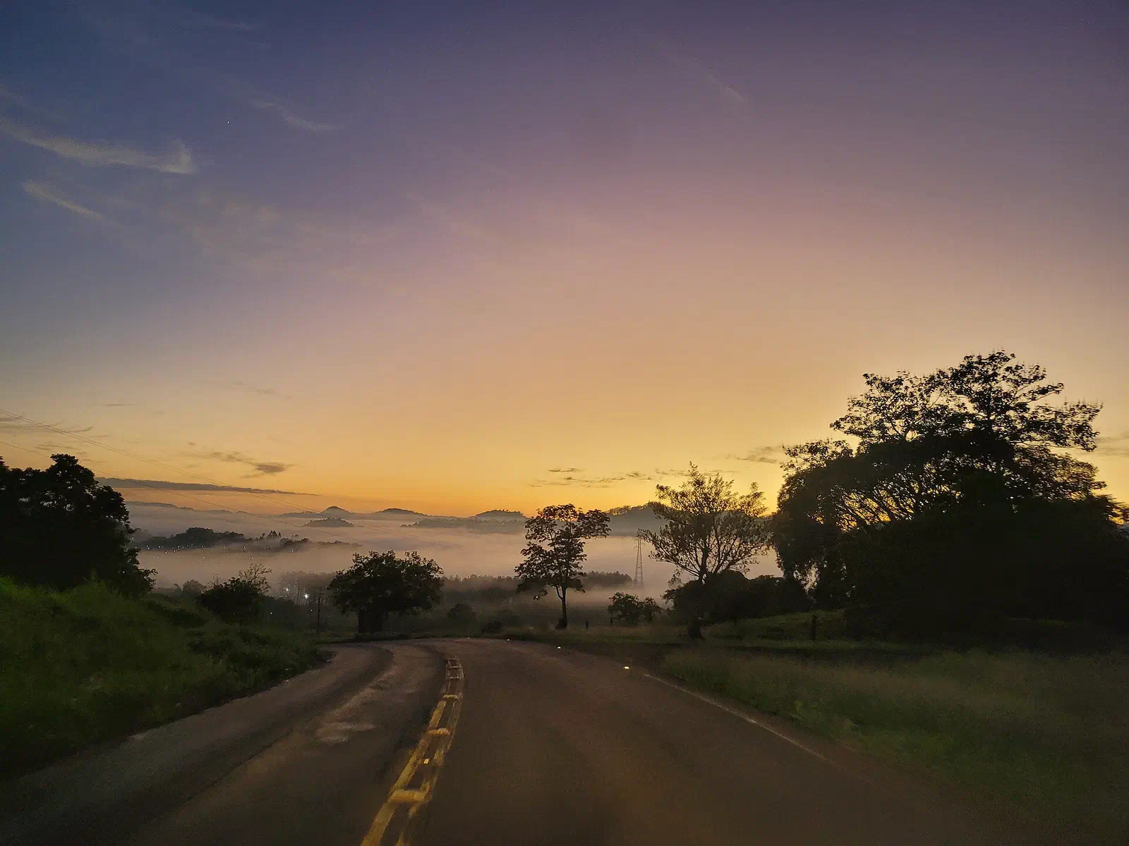 Amanhecer com neblina no vale e uma estrada rural, na rodovia SC-283 no oeste catarinense
